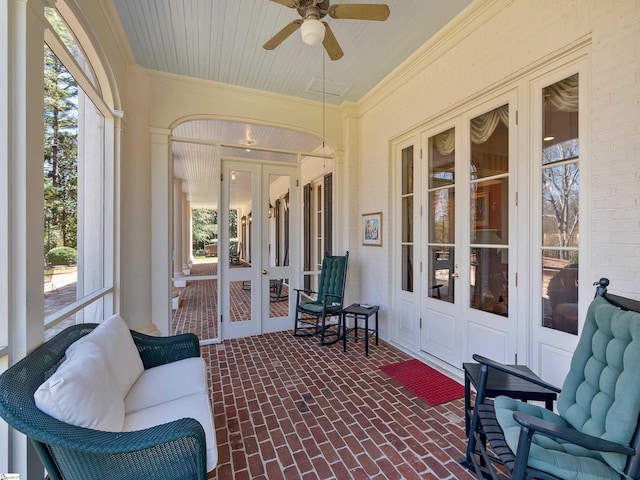 sunroom with a wealth of natural light, french doors, and a ceiling fan