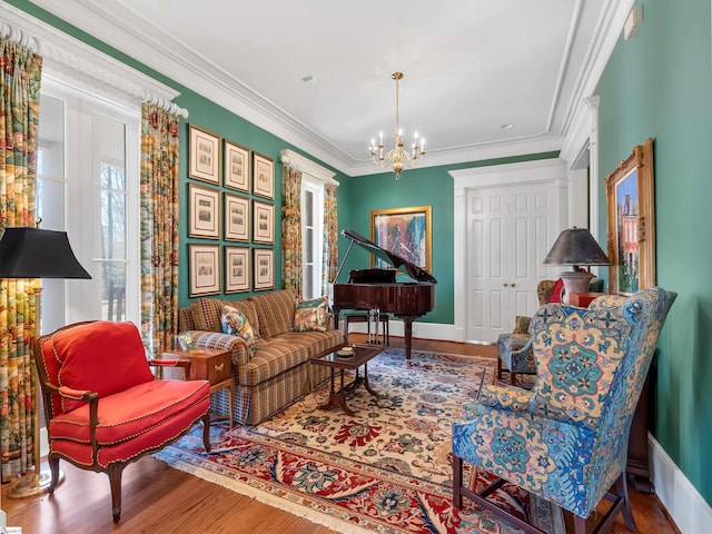 living area featuring wood finished floors, ornamental molding, and a chandelier
