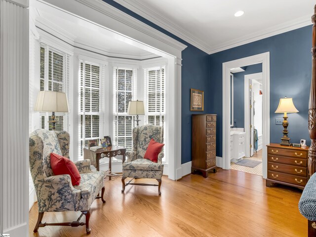 living area with light wood finished floors, baseboards, and ornamental molding