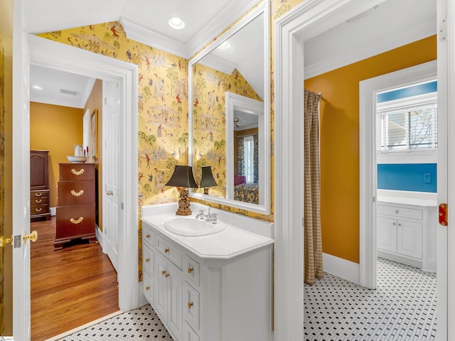full bathroom featuring wallpapered walls, ornamental molding, and vanity