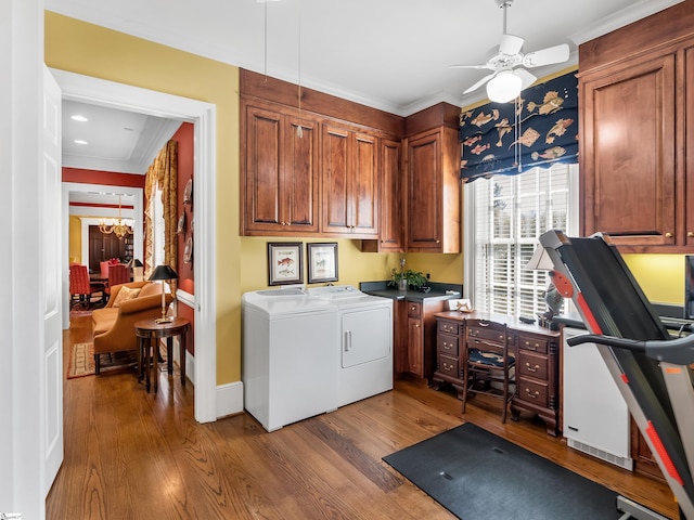 laundry room featuring cabinet space, ceiling fan with notable chandelier, washer and dryer, and wood finished floors