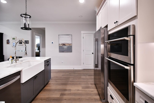 317 Encampment Blvd, Simpsonville, SC 29681 - kitchen featuring crown molding, white cabinets, wood finished floors, appliances with stainless steel finishes, and decorative light fixtures
