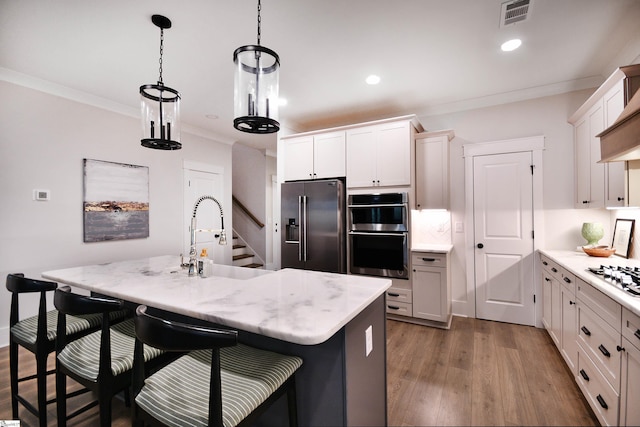 317 Encampment Blvd, Simpsonville, SC 29681 - kitchen with crown molding, a sink, wood finished floors, stainless steel appliances, and visible vents
