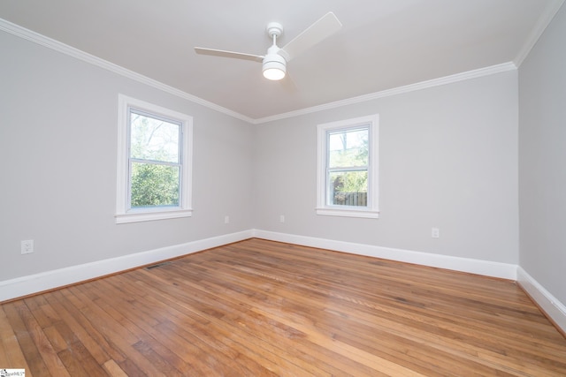 spare room featuring a ceiling fan, baseboards, ornamental molding, and light wood-style floors
