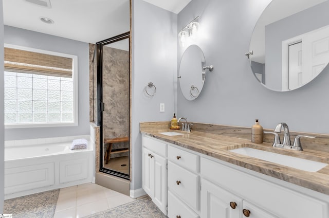 full bath with a stall shower, tile patterned floors, double vanity, and a sink