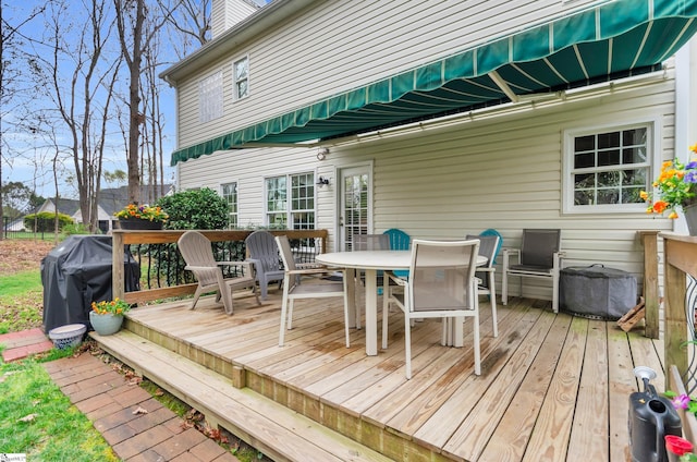 deck featuring outdoor dining area and a grill