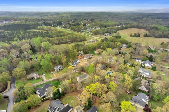 birds eye view of property featuring a wooded view and a residential view
