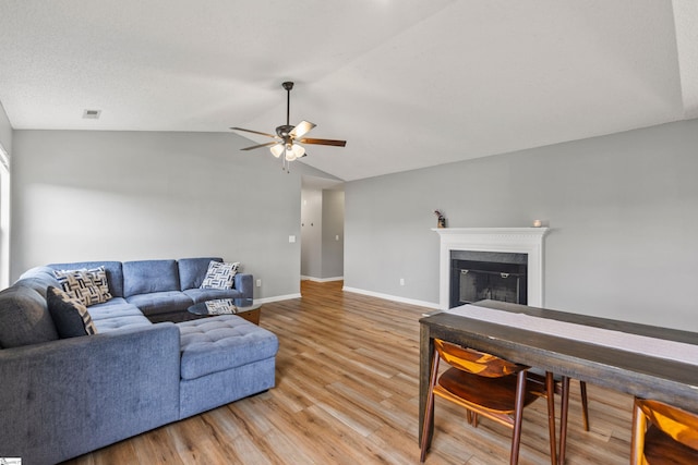 29 Parkgate Ct, Simpsonville, SC 29680 - living area featuring light wood-style flooring, ceiling fan, lofted ceiling, baseboards, and a glass covered fireplace