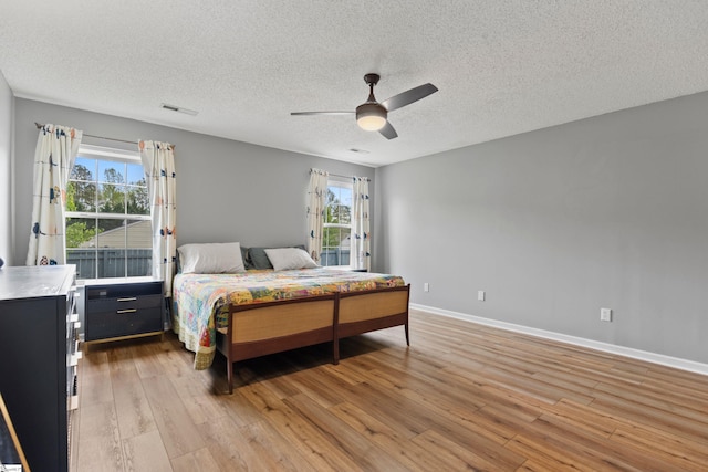 29 Parkgate Ct, Simpsonville, SC 29680 - bedroom with light wood-style floors, multiple windows, a textured ceiling, ceiling fan, and baseboards