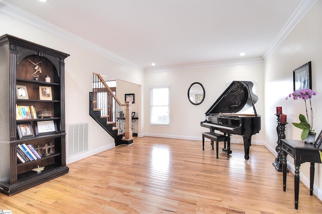 sitting room featuring crown molding, stairs, baseboards, visible vents, and light wood-style flooring