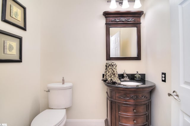 bathroom featuring baseboards, toilet, and vanity