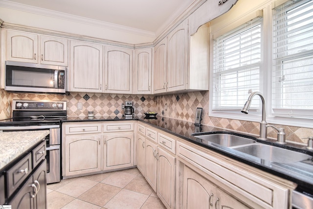 kitchen featuring crown molding, a sink, backsplash, appliances with stainless steel finishes, and light tile patterned floors