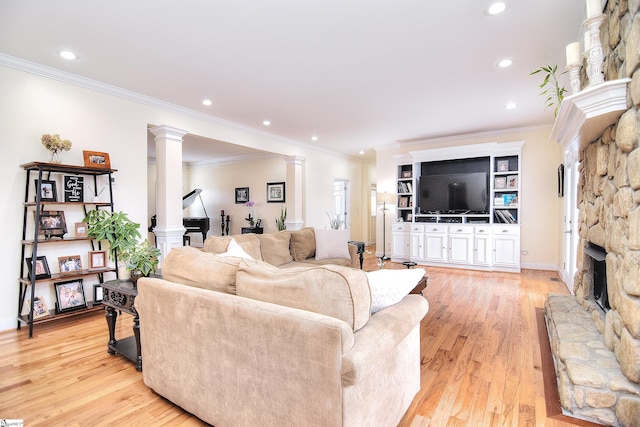 living area with light wood-style flooring, ornate columns, a fireplace, ornamental molding, and recessed lighting