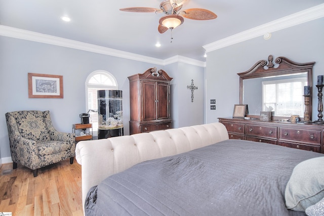 bedroom featuring multiple windows, light wood-type flooring, ornamental molding, and a ceiling fan
