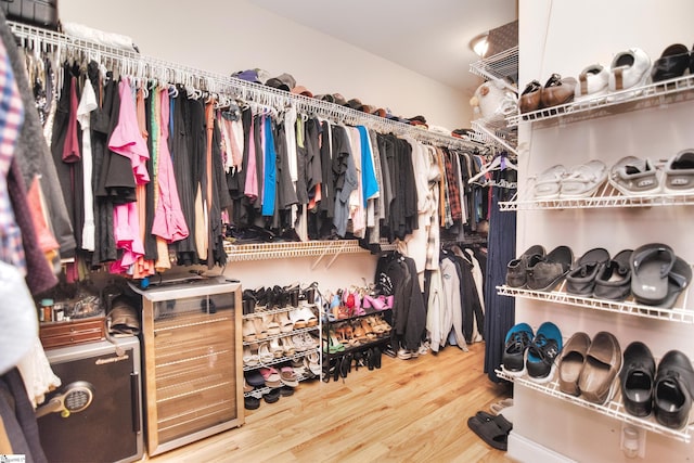 walk in closet with wood finished floors