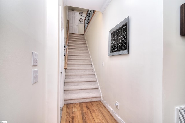 stairway with baseboards and wood finished floors