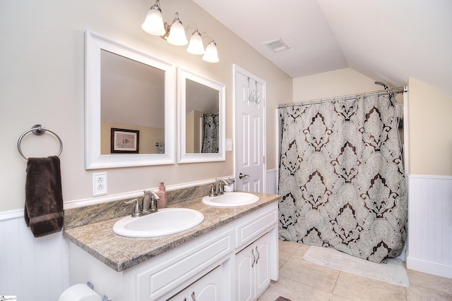 full bathroom with visible vents, a sink, tile patterned flooring, and wainscoting