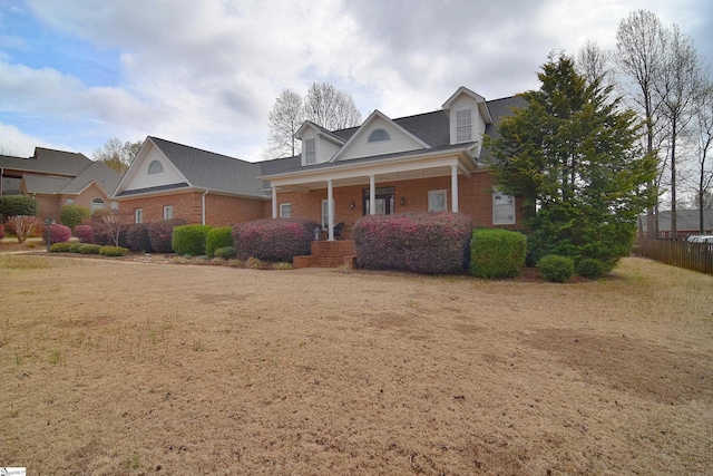 view of front of property featuring covered porch and brick siding