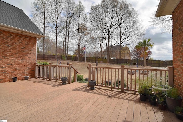 wooden terrace with a fenced backyard
