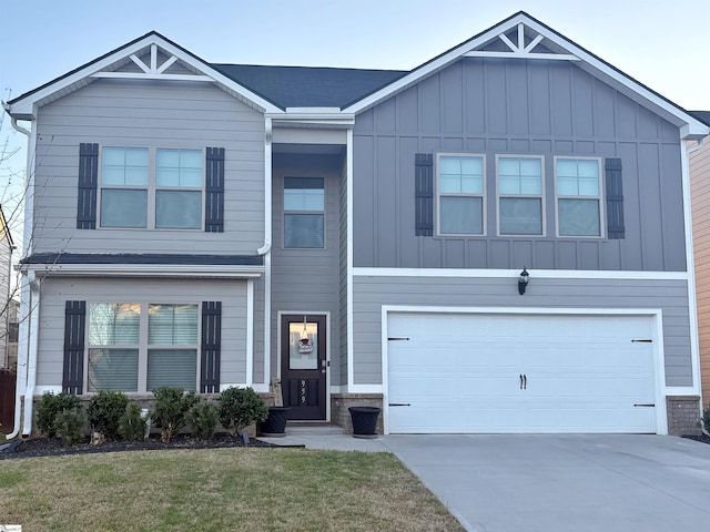 view of front of house with board and batten siding, concrete driveway, a garage, and a front lawn