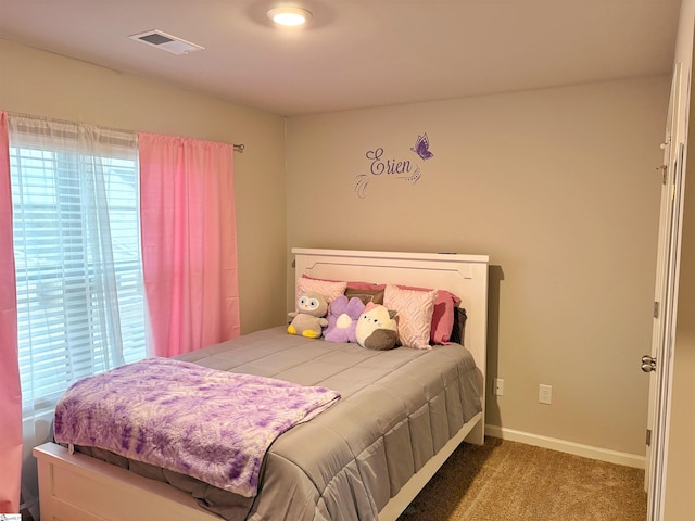 bedroom with baseboards, visible vents, and carpet