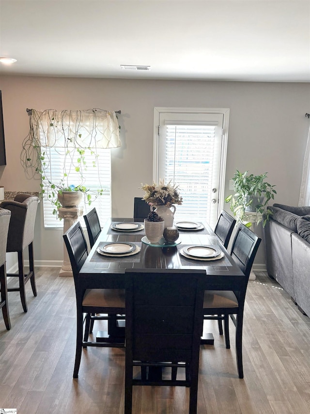 dining room with wood finished floors, baseboards, and visible vents