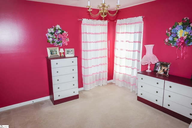 bedroom with light colored carpet, baseboards, and a chandelier