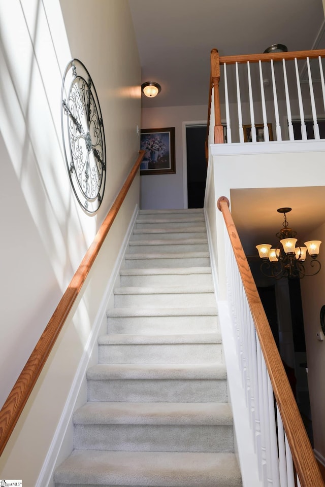 stairway with baseboards and a notable chandelier
