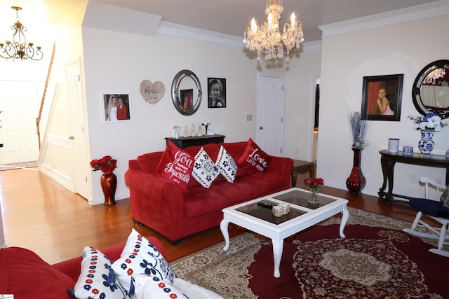 living room with ornamental molding, wood finished floors, and a notable chandelier
