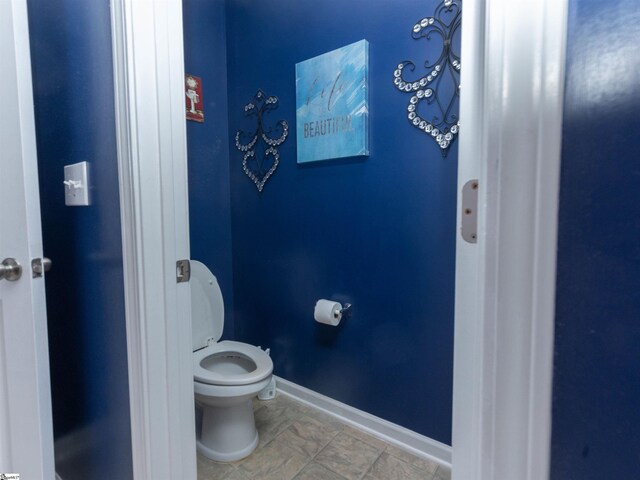 bathroom featuring toilet and baseboards
