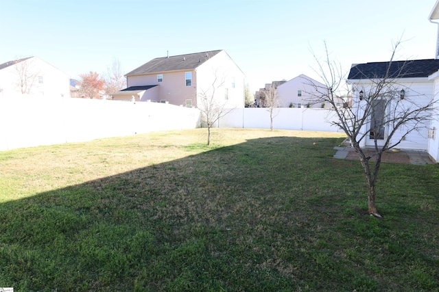 view of yard featuring a fenced backyard and a residential view