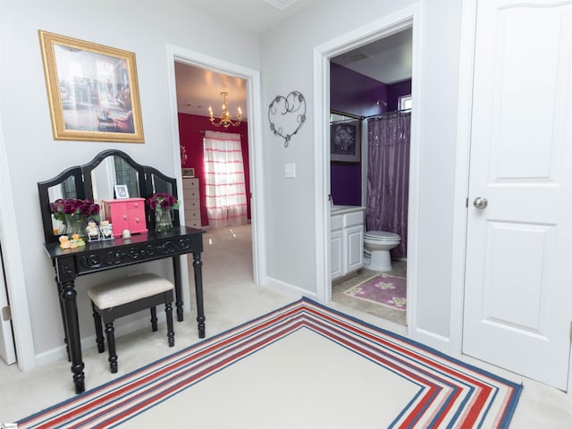 carpeted bedroom with baseboards, an inviting chandelier, and ensuite bath
