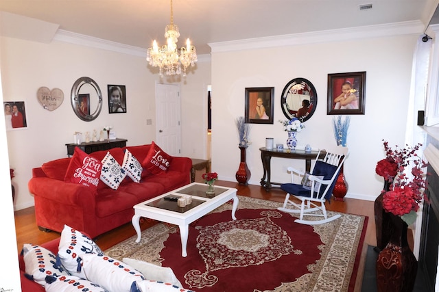 living room featuring an inviting chandelier, baseboards, wood finished floors, visible vents, and ornamental molding