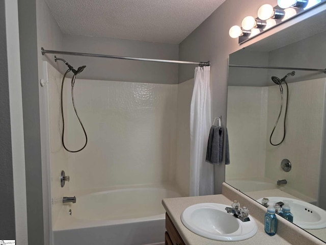 full bathroom with shower / bath combo, a textured ceiling, and vanity