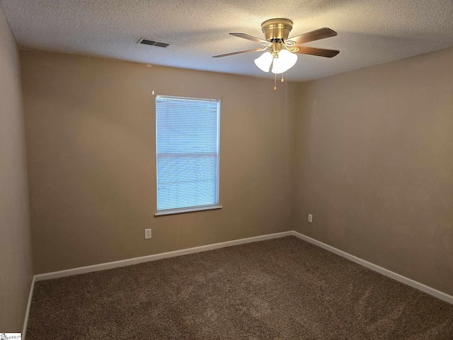 carpeted empty room with baseboards, visible vents, ceiling fan, and a textured ceiling