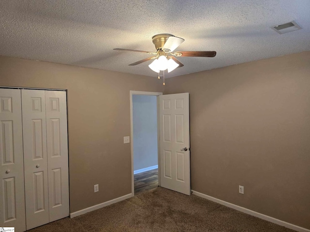 unfurnished bedroom with baseboards, visible vents, carpet floors, and a textured ceiling