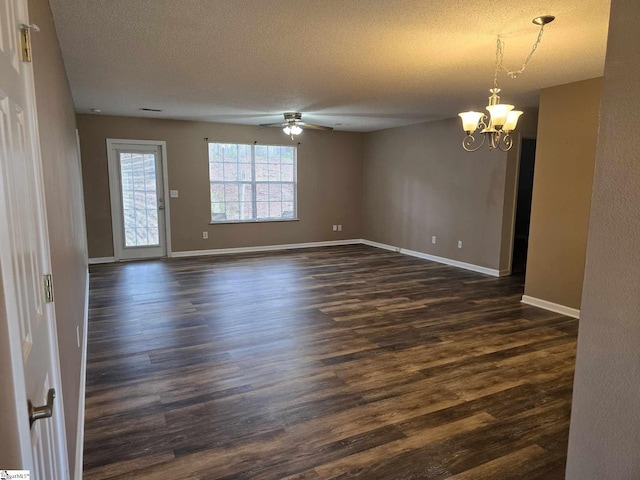 empty room featuring dark wood-type flooring, a textured ceiling, baseboards, and ceiling fan with notable chandelier