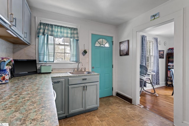 305 Morse St, Pendleton, SC 29670 - kitchen featuring decorative backsplash, light countertops, crown molding, a sink, and gray cabinetry