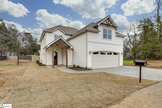 traditional-style home featuring concrete driveway, board and batten siding, fence, and an attached garage