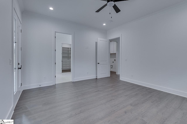 unfurnished bedroom featuring baseboards, crown molding, and wood finished floors
