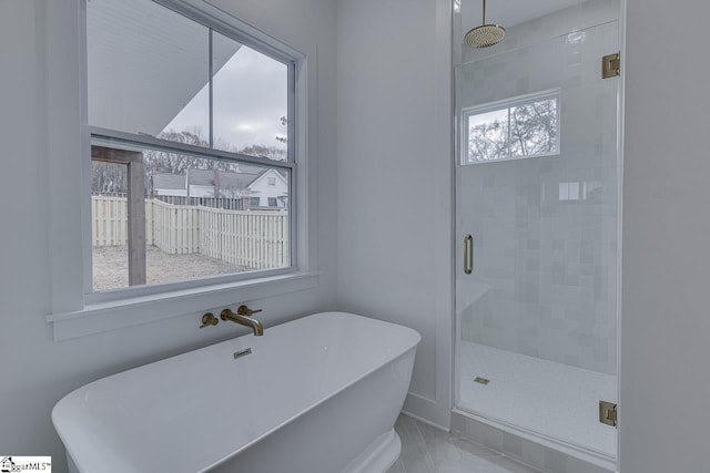 bathroom featuring a stall shower and a soaking tub