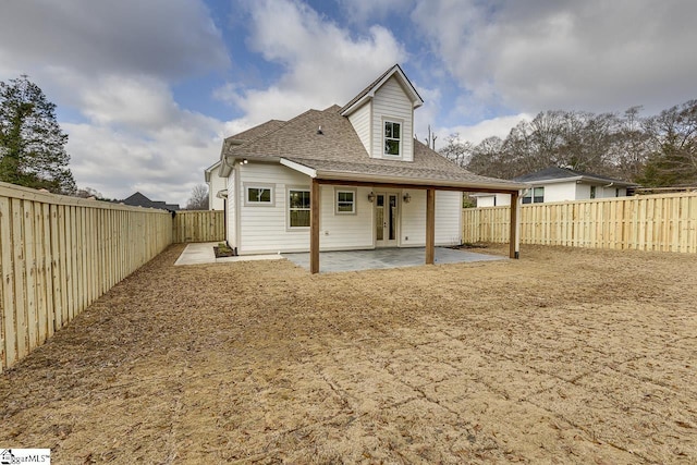 back of property featuring a patio, french doors, a fenced backyard, and a shingled roof
