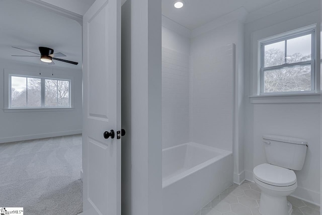 full bathroom featuring toilet, ceiling fan, baseboards, and a wealth of natural light