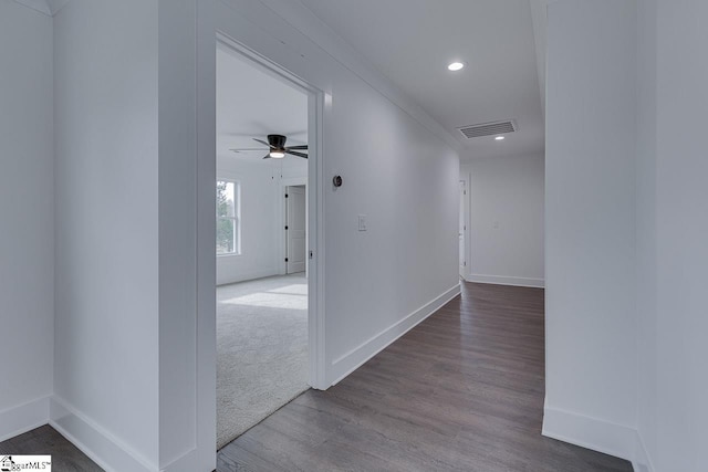 hall with visible vents, baseboards, recessed lighting, wood finished floors, and carpet flooring