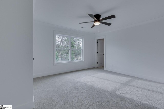 unfurnished room featuring baseboards, crown molding, carpet floors, visible vents, and ceiling fan