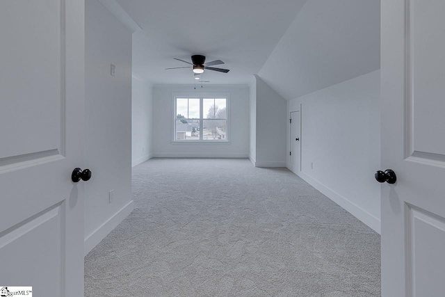 additional living space with carpet flooring, baseboards, a ceiling fan, and vaulted ceiling