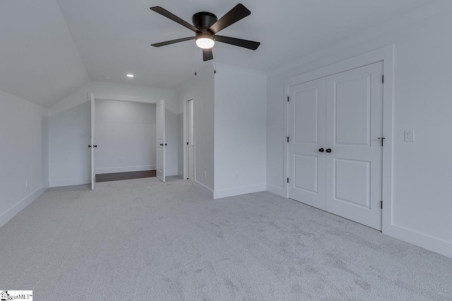 unfurnished bedroom featuring crown molding, ceiling fan, carpet, lofted ceiling, and baseboards