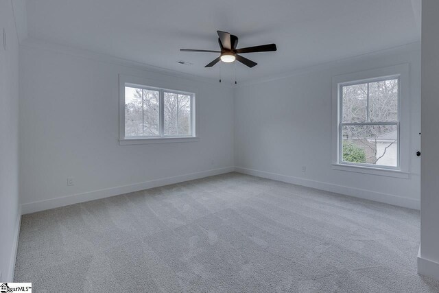 unfurnished room featuring baseboards, light colored carpet, ornamental molding, and ceiling fan