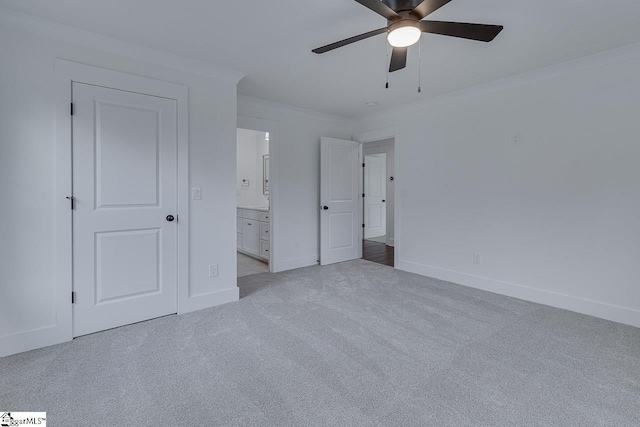 unfurnished bedroom featuring ornamental molding, baseboards, connected bathroom, and carpet