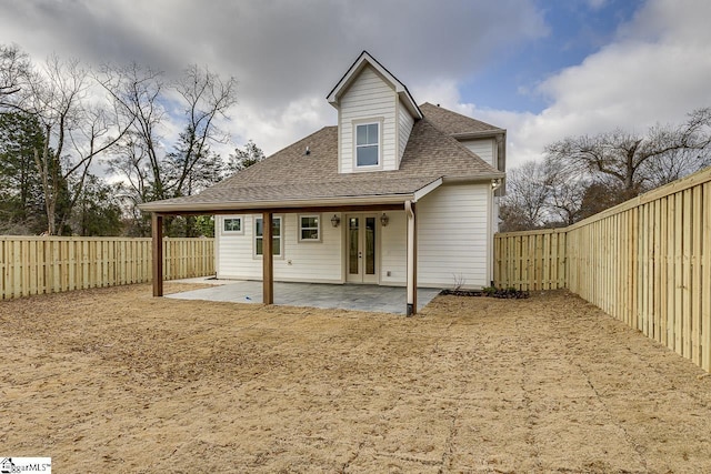 back of property with a patio, french doors, a fenced backyard, and a shingled roof
